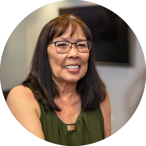 Smiling middle-aged Asian woman in green blouse showing her Full mouth All-on-4 Dental Implants