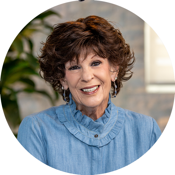 Elderly female patient with brown hair smiling, showing her all-on-4 dental implants by Dr. Silegy