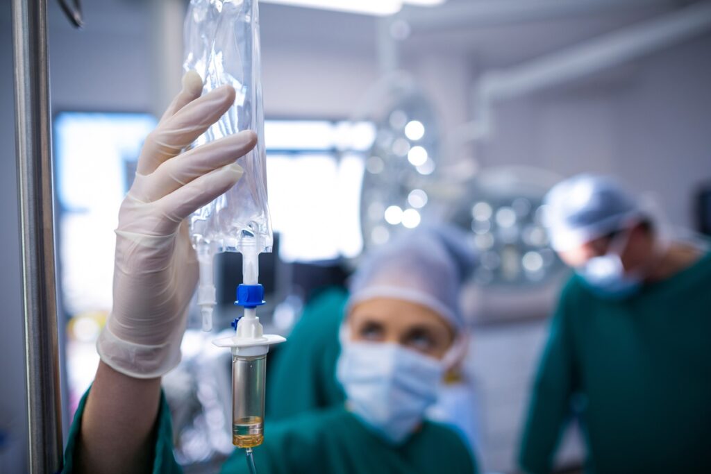 Female surgeons adjusting iv drip in operation theater